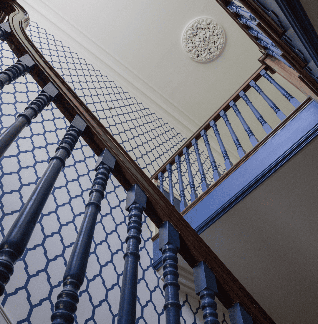 Blue staircase with decorative ceiling detail.